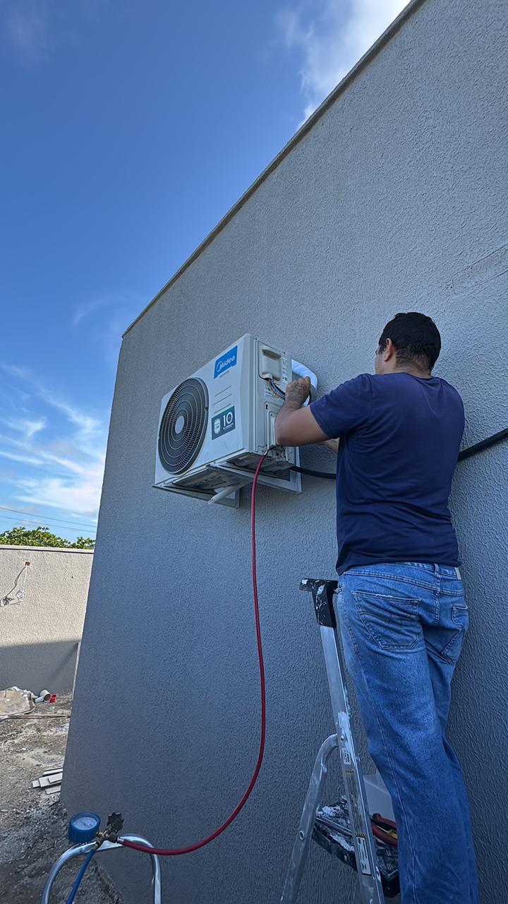 Técnico realizando instalação de unidade externa de ar-condicionado em residência